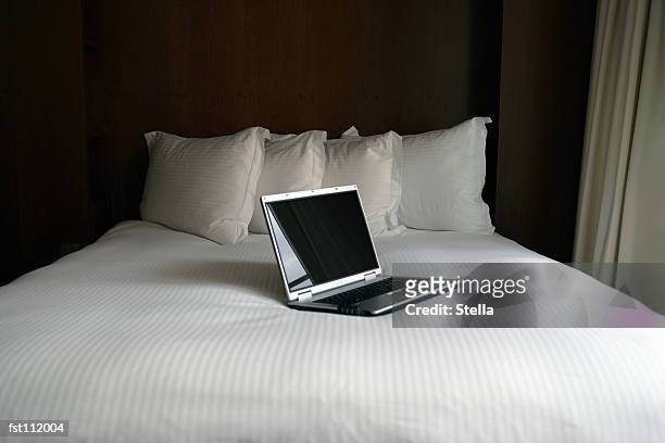 laptop computer on bed - stella stockfoto's en -beelden