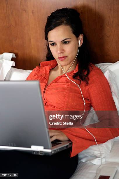 woman with mp3 player and laptop computer - stella stock-fotos und bilder