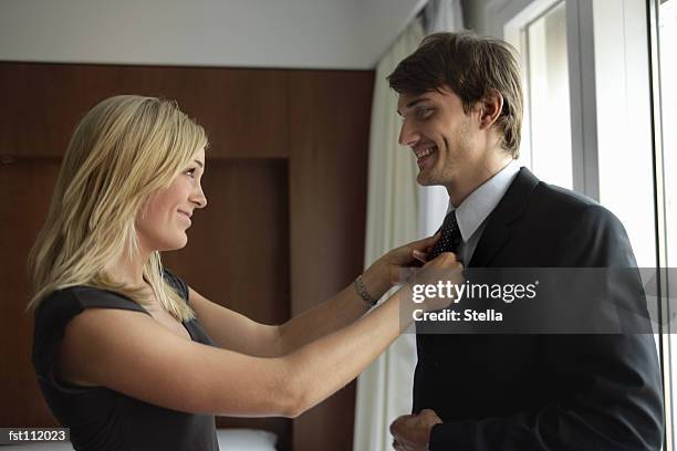 woman tying man?s necktie - stella stockfoto's en -beelden