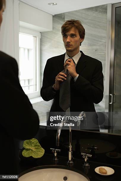 man tying his necktie in the mirror - saboneteira imagens e fotografias de stock