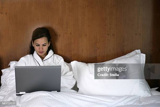 woman using laptop computer in bed - stella stock pictures, royalty-free photos & images