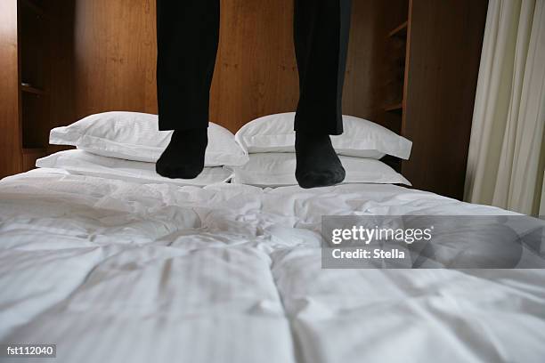 man jumping on hotel bed - stella stock pictures, royalty-free photos & images