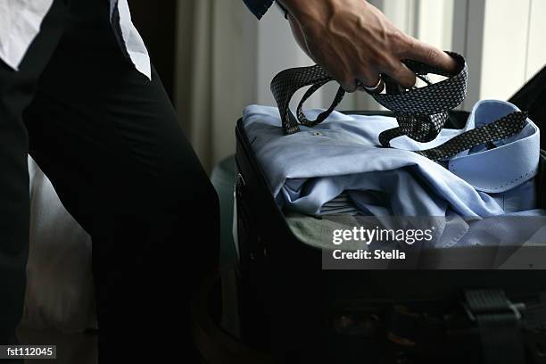 businessman packing a suitcase - stella stock-fotos und bilder