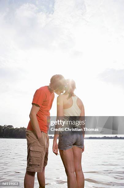 man kissing woman?s shoulder by lake - thomas's imagens e fotografias de stock