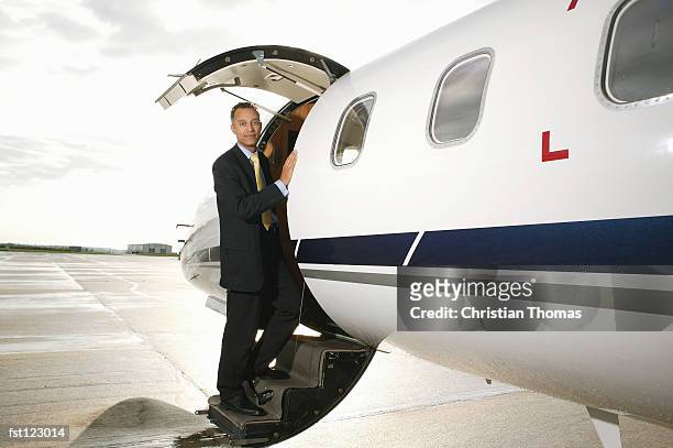 businessman standing on a private airplane?s steps - thomas's imagens e fotografias de stock