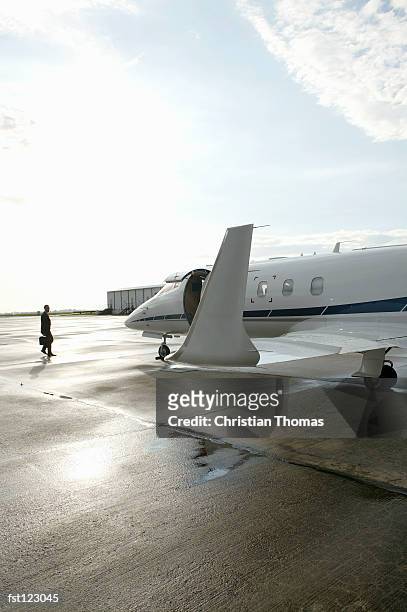 businessman walking towards a private airplane - thomas photos et images de collection