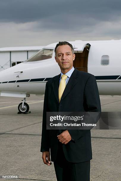businessman standing in front of a private airplane - aviación civil fotografías e imágenes de stock