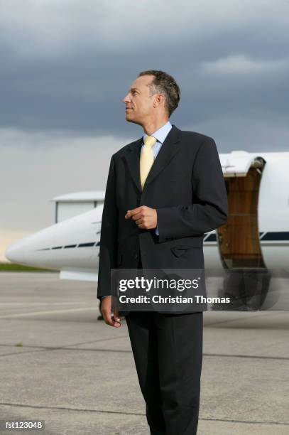businessman standing in front of a private airplane - aviación civil fotografías e imágenes de stock