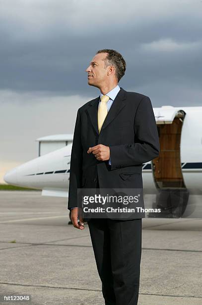 businessman standing in front of a private airplane - thomas photos et images de collection