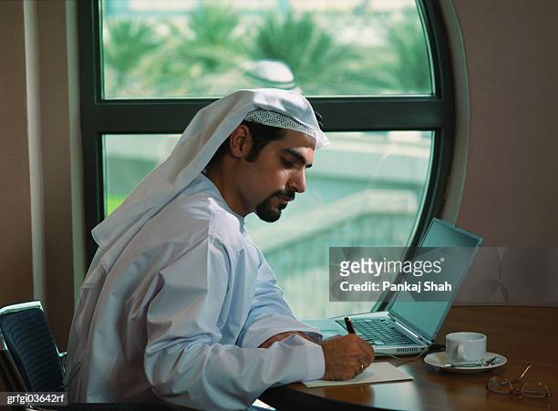 businessman from the middle east in office writing - shah stock-fotos und bilder