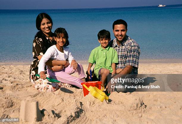 family of four on the beach - shah stock-fotos und bilder