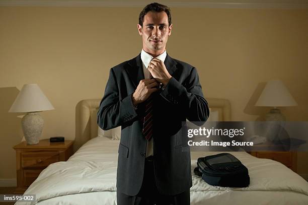 businessman adjusting necktie - smirk stock pictures, royalty-free photos & images