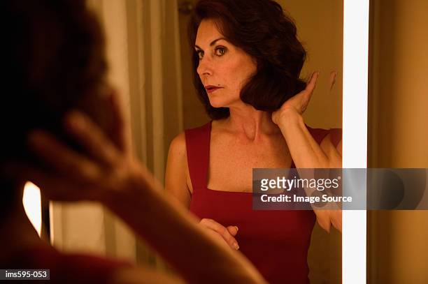 woman looking in mirror - ijdel stockfoto's en -beelden