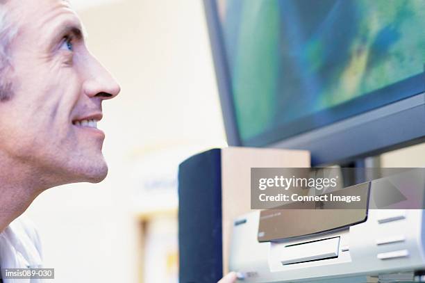 man looking at television - dvd player stock pictures, royalty-free photos & images