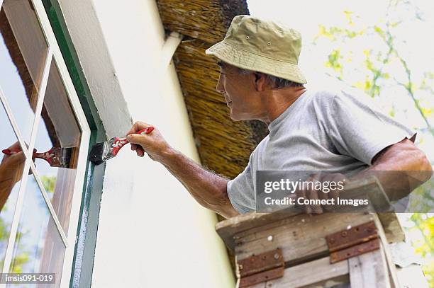 man painting house - windowframe stockfoto's en -beelden