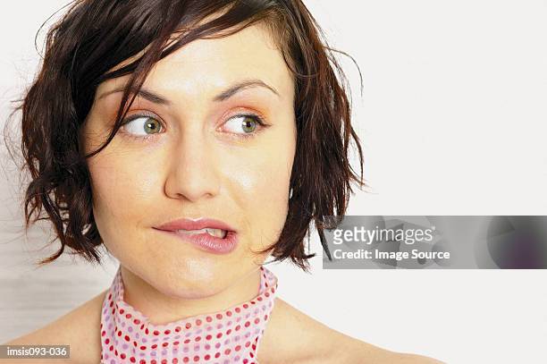 woman biting lip - guilt stock pictures, royalty-free photos & images