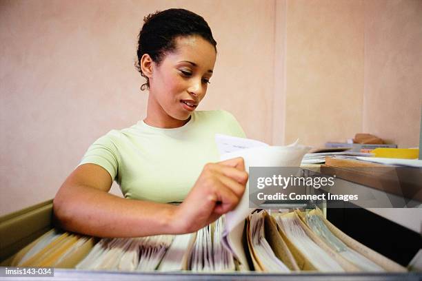 woman using the filing cabinet - filing cabinet stock pictures, royalty-free photos & images