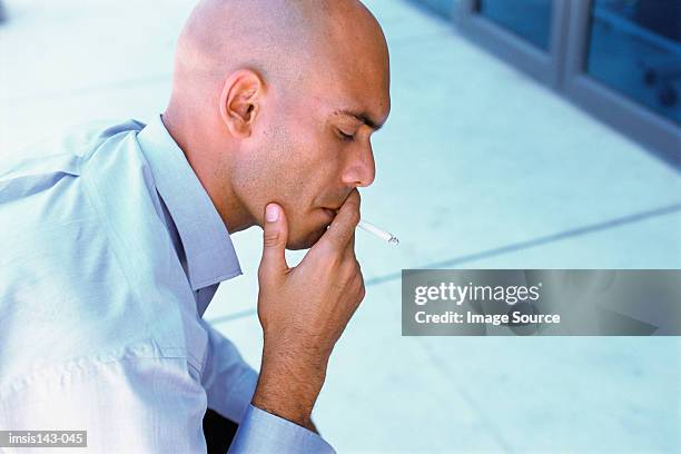 man having a smoke - completely bald stock pictures, royalty-free photos & images