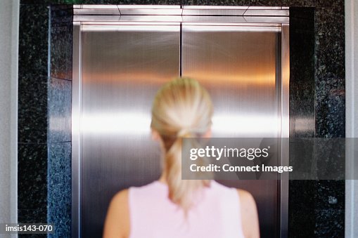 Woman waits in front of lift Woman waits in front of lift