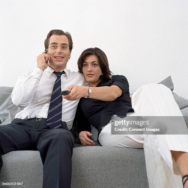 couple sitting relaxed on sofa - controlling girlfriend stock pictures, royalty-free photos & images