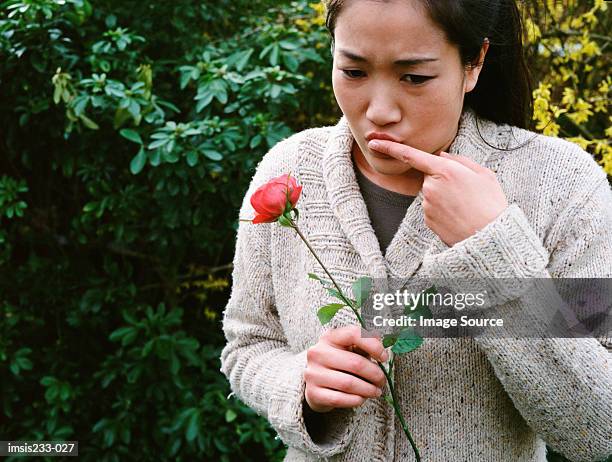 girl hurts her finger on a rose thorn - thorn stock pictures, royalty-free photos & images