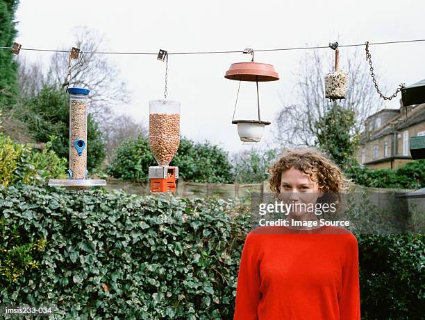 woman by bird tables - bird feeder stock pictures, royalty-free photos & images