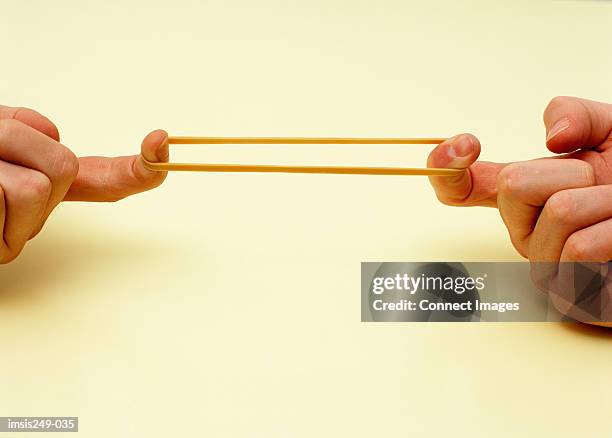 stretching rubber band - elastiekje stockfoto's en -beelden