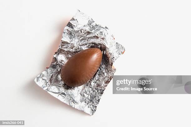 chocolate in foil wrapper - chocolate foil stock-fotos und bilder