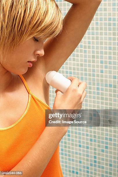 young woman applying deodorant - deo frau badezimmer stock-fotos und bilder