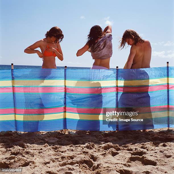 girlfriends behind a windbreak - beach shelter stockfoto's en -beelden