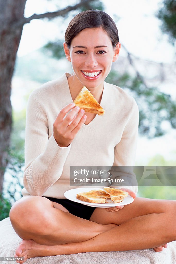 Woman eating toast in garden