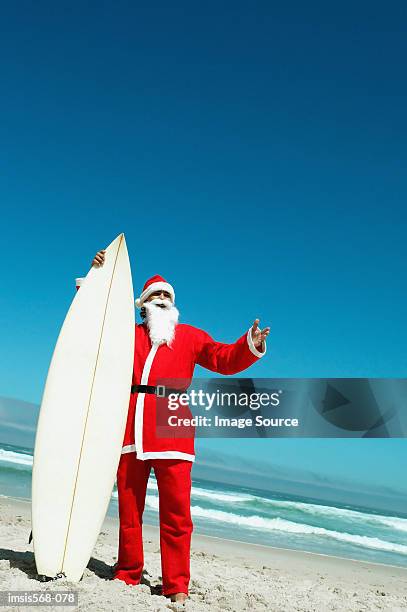 christmas on the beach - surfing santa stock pictures, royalty-free photos & images