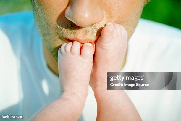 dad kissing baby's feet - kissing feet stock pictures, royalty-free photos & images