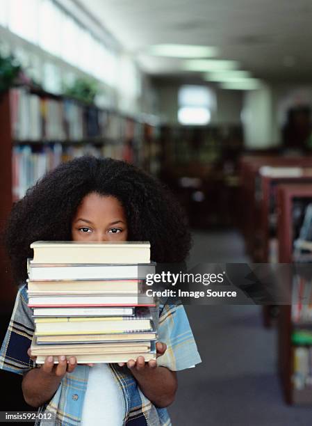 boy holding stack of books - text book stockfoto's en -beelden