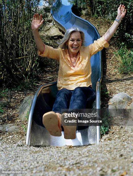 laughing woman on slide. - slide stock pictures, royalty-free photos & images