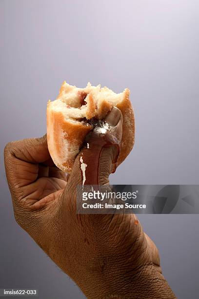 man holding a jam doughnut - donut man stock pictures, royalty-free photos & images