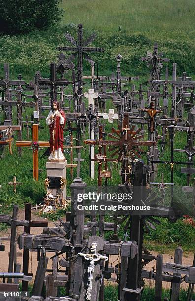 crucifixes surrounding statue on hill of crosses, siauliai, lithuania - craig pershouse stockfoto's en -beelden