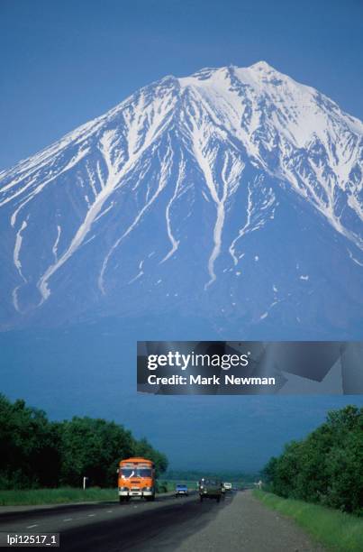 highway with koryaksky volcano in the background, petropavlovsk-kamchatsky, russia - vulcano koryakskij foto e immagini stock