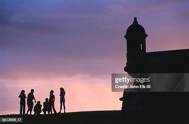 sentry tower of city wall and people at sunset, low angle view, san juan, puerto rico - puerto stock pictures, royalty-free photos & images