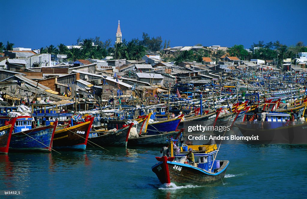 Fishing boats docked in port at mouth of Phan Thiet river on South China Sea coast, Phan Thiet, Binh Thuan, Vietnam, South-East Asia