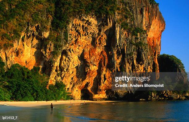 sunset on cliffs at phra nang beach, krabi, krabi, thailand, south-east asia - east beach stock pictures, royalty-free photos & images