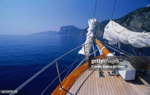 deck of yacht sailing past cliffs of gulf of orosei. - tyrrhenian sea stock pictures, royalty-free photos & images