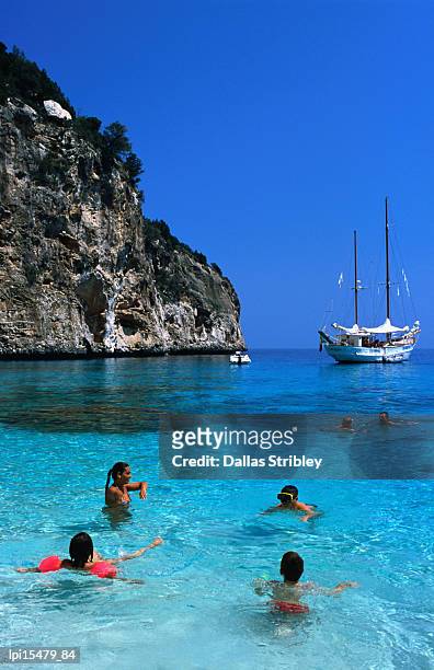 tourists swimming in waters of cala mariolu in gulf of orosei. - tyrrhenian sea stock pictures, royalty-free photos & images