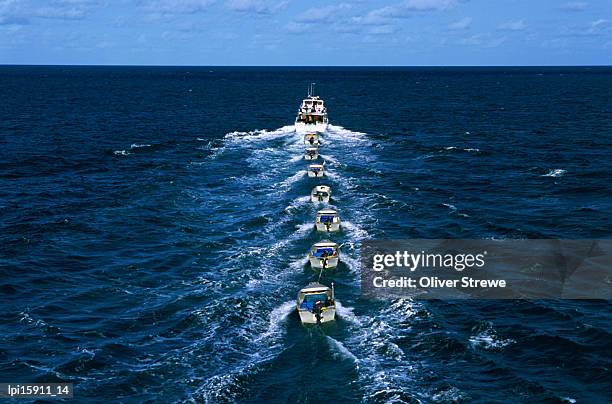 torres strait fishing boat towing seven dories (small dinghies), australia - fishing line ストックフォトと画像