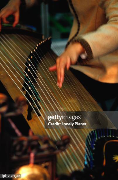 student playing gu zheng (chinese zither) in shop in xuanwu (qianmen). - qianmen stock pictures, royalty-free photos & images