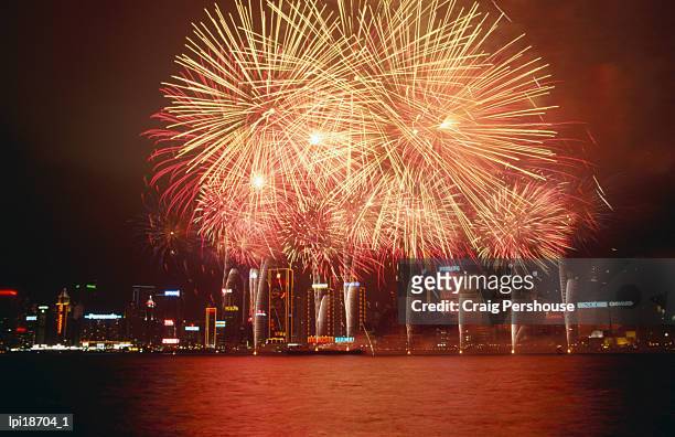 fireworks display over victoria harbour for chinese new year, low angle view, hong kong, china - hong kong stockfoto's en -beelden