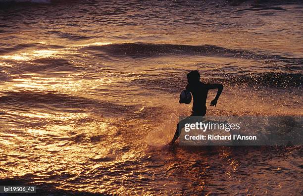 boy playing ball on galle beach at sunset, colombo, sri lanka - general economy as central bank of sri lanka looks to contain rising inflation stockfoto's en -beelden