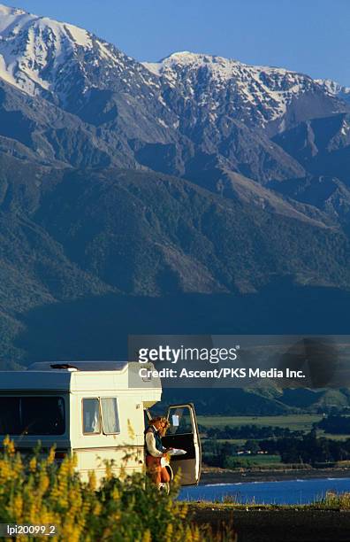 woman reading map in campervan with mountain behind, kaikoura, new zealand - travel14 fotografías e imágenes de stock