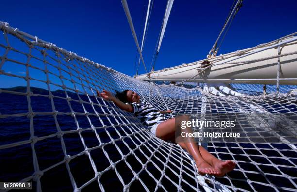 woman lying on boat net, virgin islands (uk) - travel14 stock pictures, royalty-free photos & images