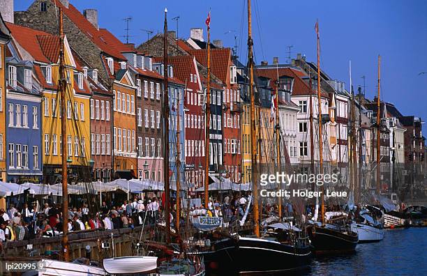 yachts moored in front of cafes at nyhavn, copenhagen, denmark - sontregio stockfoto's en -beelden